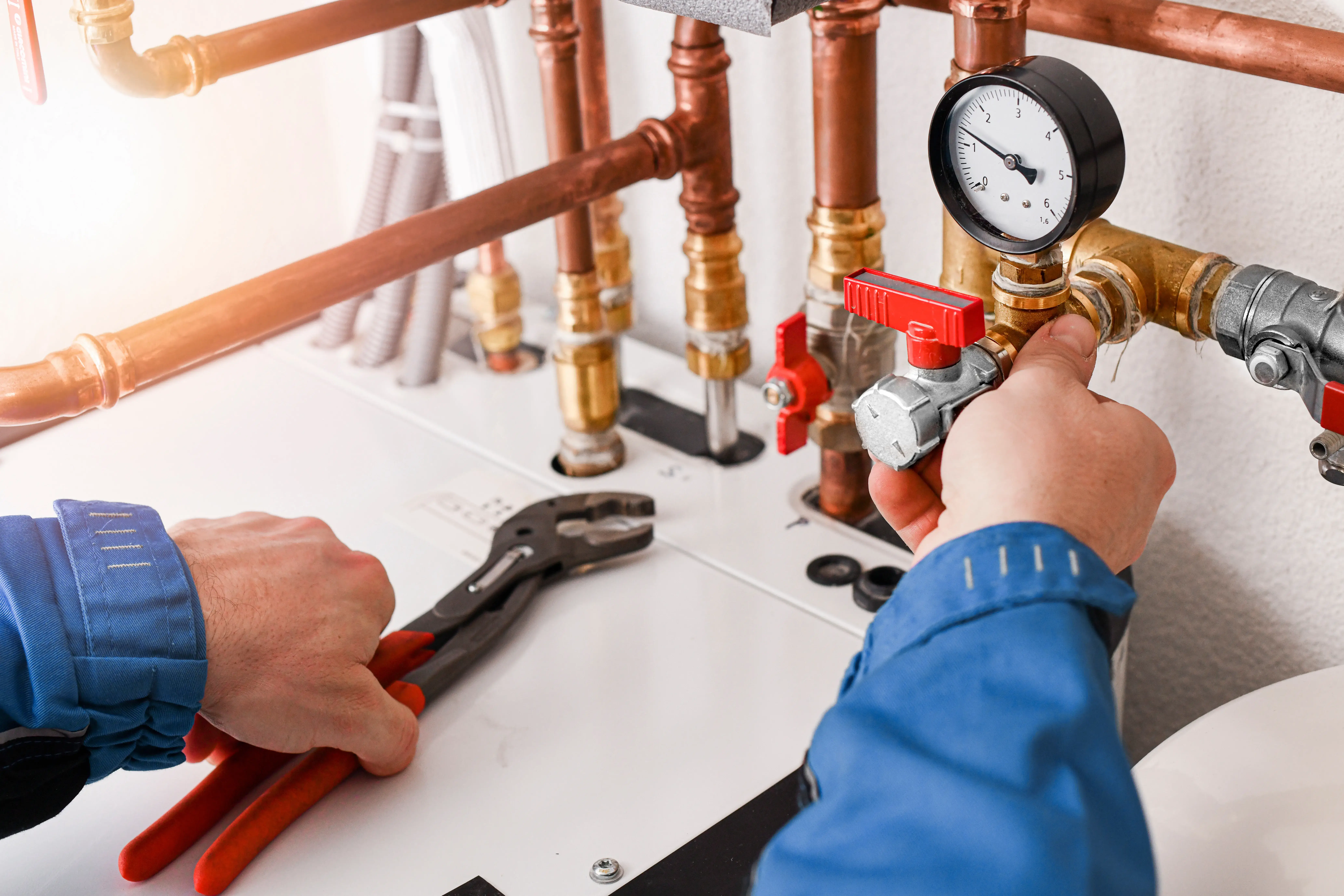 A plumber working on a pipe in a bathroom.